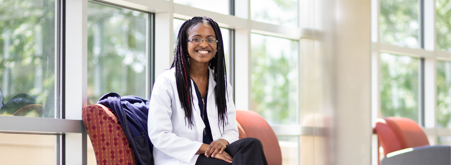 Female histotechnology student relaxes in common area of SHRP building.